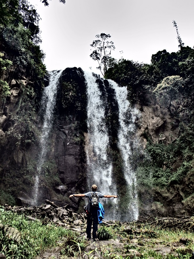 Rhys standing beneath the waterfall